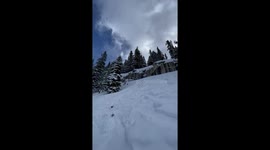 skier does big front flip off a cliff