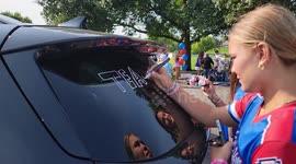 A suburban girls' softball team decorates and celebrates leading up to them being sent off by their family as they all get onto a large bus