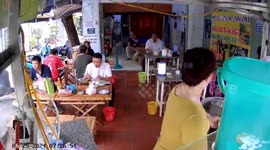 Cat sits overhead watching its owner prepare food at Ho Chi Minh City eatery
