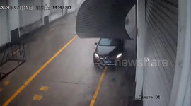 Woman narrowly avoids being hit by shop shutter torn off by winds in China
