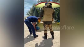 Rescuers catch snake near beachgoer's tent and secure it in plastic bottle