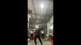 A man demonstrates the skill of using his mouth and nose to balance two sharp knives