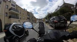 Ultra small tiny french car Renault Twizy microcar performs dangerous overtaking and changes lane without turn signal. Saint-Cyr-l'Ecole, territory of Versailles, Paris suburb. 22 july 2024