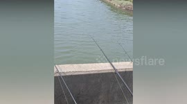 Armed soldiers surprise fisherman as they line up next to him for military drill