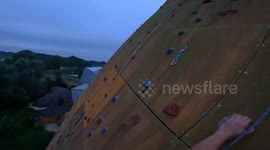 Duo scale world's tallest freestanding climbing wall - before base jumping off