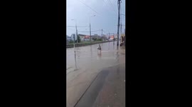 Girl rides scooter through flooded Moscow road