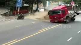 Motorbike driver escapes being buried by sand pouring out of trailer
