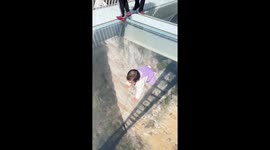 Fearless toddler crawls across glass bridge in China