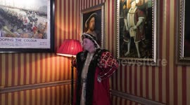 Horrible Histories Terrible Tudors star Neal Foster in character poses in front of paintings