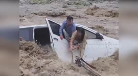 Police rescue couple trapped in car swallowed up by flash floods in China