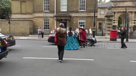Horrible Histories Terrible Tudors stars Neal Foster and Emma Swan in character walk across the street.