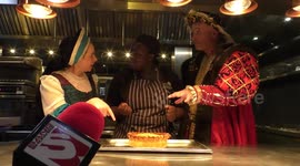 Horrible Histories Terrible Tudors stars Neal Foster and Emma Swan in character watch a pie being served.