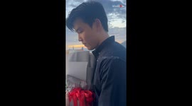 Boy proposes girlfriend at the seaside with a ring and bouquet