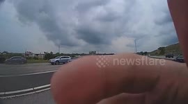Police officer holds traffic to help family of ducks cross busy highway