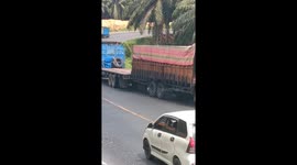 the moment when a large truck saved a truck stuck on an uphill road in Indonesia, by pushing it backwards