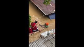 Family float to safety on polystyrene board through typhoon floods