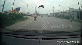 A young female passenger gets her jacket stuck in the wheel of a motorbike, almost causing a rear end collision. The motorbike driver pulls over to try to fix it.