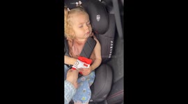 Adorable girl refuses to give up her favorite snack even while she's asleep