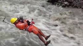 Official rescues child while ziplining over inundated river in northern India