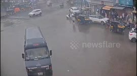 Sign collapses onto cars and pedestrians during storm in India