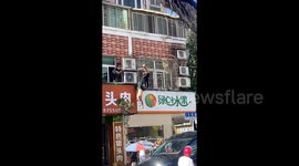Good Samaritans rescue air conditioner installer fainting and hanging upside-down from window in China