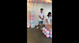 Couple surprised with gender reveal party box that starts with blue balloons but turns pink