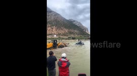 Digger used to rescue motorists after car gets stranded in raging river in China