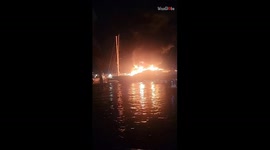 Man captures harrowing footage of yacht fully engulfed in flames at night
