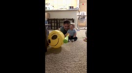 Dad and son enjoy playtime with a smiley balloon and endless giggles