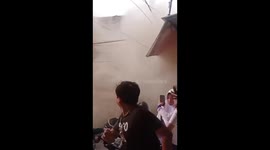 Three-storey building collapses in Indonesia, covering passersby in dust