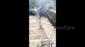 Tourists evacuated as torrential rains turn mountain into waterfall in China