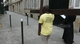 Man walking with a christian cross in the streets of Paris with a Procession. The scene remind the context of harassment against christians in the world.  # Jesus Christ.  (Paris, France, Place de Finlande.)  A few days ago Christians expressed their di