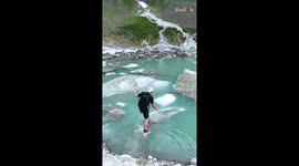 Boy jumps over ice flakes on a glacier with ease and fun