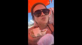 Woman's relaxing beach picnic interrupted by surprise bug landing on shoulder
