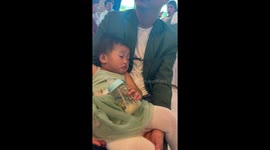 Sleepy baby struggles to keep her eyes open at wedding