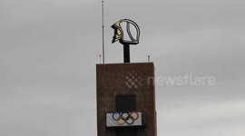 Spinning giant firefighter helmet of the fire station of Poissy, Paris suburb, France.  A giant flag of the Olympic rings hangs from the top of the building for the Paris Olympics 2024.  (Video: 13 aug 2024)