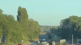 Bizarre moment man hangs out of van - travelling down motorway