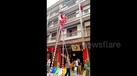 China: A stilt walker uses fan during his performance in Yueyang