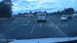 Biker without helmet dangerously weaves in and out of traffic before jumping red light