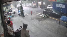 Woman holding umbrella survives falling tree amid storm