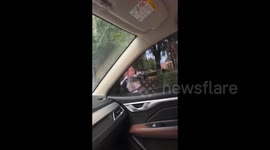 China: Child makes a funny face into car window in Zhoukou