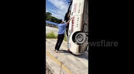 China: The driving school coach is helping a student get out of the car that has tipped up