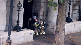 Firefighters seen at Somerset House as fire smoulders into the evening