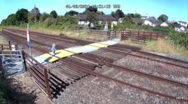 Mother and son cross tracks as train approaches in Wales