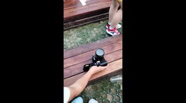 Chinese man attracts pigeons with food on camera lens