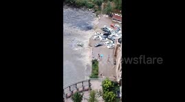 Flash floods from rainstorm engulf streets and sweep away vehicles in China