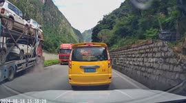Driver leaps from taxi when car carrier topples over onto his vehicle