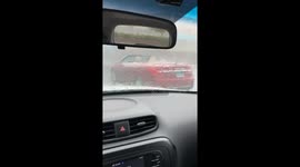 A very nice red convertible with top down gets hammered by torrential rain.
