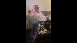 Cat drinks from glass as surprised owner looks on in Liverpool, United Kingdom