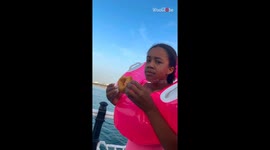 Beach day twist: Seagull swoops in and snatches doughnut from the girl's hand